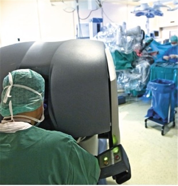 Patienten fassen Vertrauen in Roboter-Operationen Roboter in der Urologie: Der leitende Arzt steht an der Bedieneinheit (vorn), das Op-Team am Tisch beim Patienten.