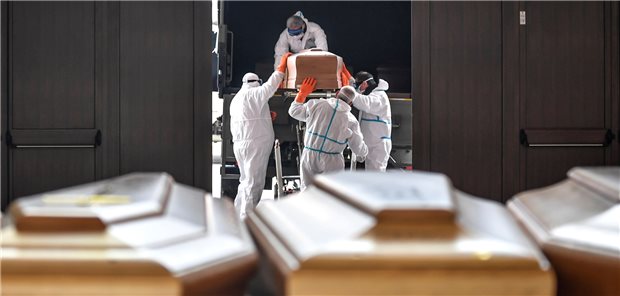 „Dieses Trauma wird mich ein Leben lang begleiten“ Särge, die aus der Gegend von Bergamo eintreffen, werden im März von Arbeitern in Schutzanzügen aus einem Militärfahrzeug in ein Gebäude des Friedhofs von Cinisello Balsamo getragen.