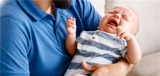 Säugling auf dem Arm seines Vaters