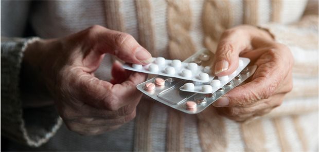 Eine ältere Person hält drei Blisterstreifen mit Tabletten zwischen beiden Händen.