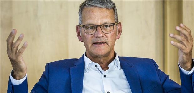 Krankenhausgesellschaft fordert Inflationsausgleich von vier Prozent DKG-Vorstandsvorsitzender Dr. Gerald Gaß: ein Herr mit graumelierten Haaren, brauner Brille, blauer Anzug, die Hände schwungvoll erhoben.