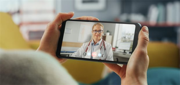 Eine Patientin spricht per Videosprechstunde mit einer Ärztin, die auf einem Handy zu sehen ist.