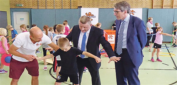 Es darf gespielt werden Schulpause der etwas anderen Art: fit4future-Coach Frédéric Trigault hilft einem Schüler, sich auf dem Balance-Brett zu halten. Hermann Gröhe und Andreas Storm (rechts) begleiten das Präventionsprojekt.