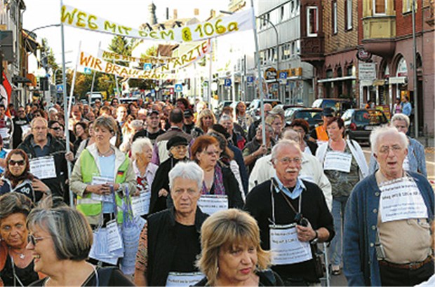 300 Patienten gehen für ihren Arzt in Neu-Isenburg auf die Straße Schulterschluss von Arzt und Patienten: "Weg mit dem § 106 a" steht auf einem Transparent bei der Demonstration für Dr. Siegfried Spernau.