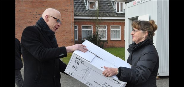 Neues KV-Coronavirus-Diagnostikzentrum geht an den Start Schutzkleidung für das neue KV-Diagnostikzentrum in Rendsburg: Landrat Rolf-Oliver Schwemer übergibt diese an die KV-Notdienstbeauftragte Gloria Linda Lawrenz.