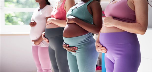 Mehrere schwangere Frauen stehen in einer Reihe.