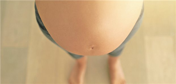Bauch einer schwangeren Frau von oben fotografiert
