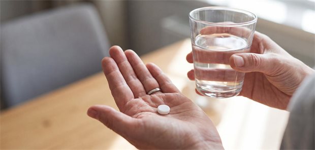 Hände hallten Tablette in linker Hand und Glas Wasser in rechter Hand