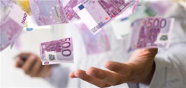 Welche Eigenschaften helfen, reich zu werden Eine Hand fängt 500-Euro-Geldscheine auf, die durch die Luft wirbeln.