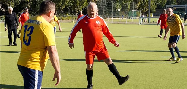 Spieler vom SC Siemensstadt (gelbes Trikot) und vom TSV Mariendorf (in rot) spielen Walking Football.