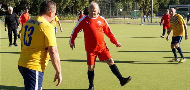 Spieler vom SC Siemensstadt (gelbes Trikot) und vom TSV Mariendorf (in rot) spielen Walking Football.