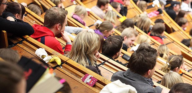 Schummelei in Studien entlarven Studenten hören einem Professor im Hörsaal zu.