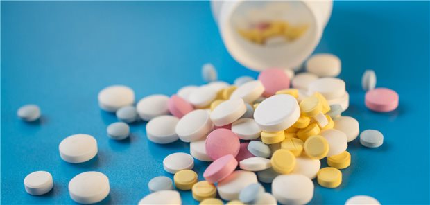 Tablets to maintain the correct functioning of the human cardiovascular system on a blue background close-up