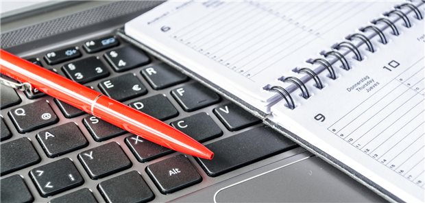 EIn Terminkalender liegt auf einem Laptop.