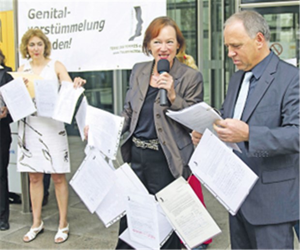 Terres des Femmes-Chefin Irmingard Schewe-Gerigk überreicht BMG-Vertreter Robert Schüßler die Unterschriften.