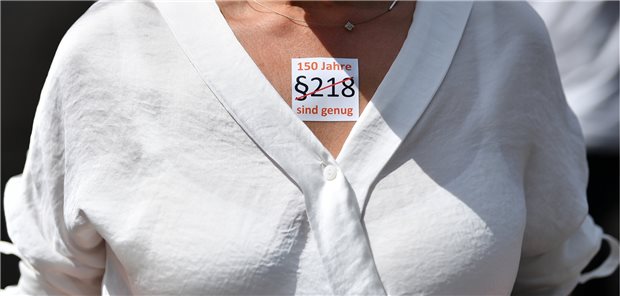Pro familia mit Aktionen gegen Paragraf 218 Thüringen, Erfurt im Juni: „§ 218. 150 Jahre sind genug“ steht auf dem Sticker, den eine Teilnehmerin der Versammlung des pro familia Landesverbands vor dem Landtagsgebäude am Rande der Plenarsitzung des Thüringer Landtages trägt.