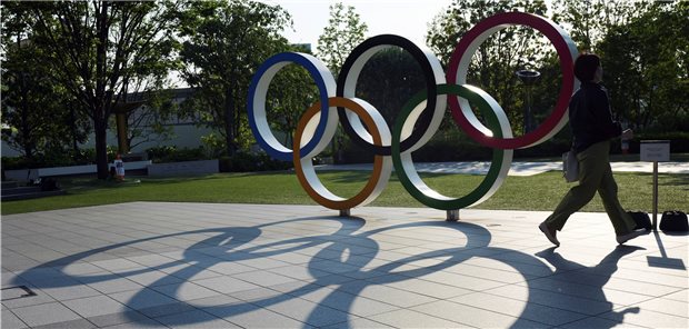 Olympia könnte ohne Publikum stattfinden Tokio: Eine Frau geht an den Olympischen Ringen in der Nähe des Nationalstadions vorbei. In knapp vier Wochen sollen in Tokio die Olympischen Spiele eröffnet werden. Das umstrittene Sport-Spektakel steht weiter in der Kritik, zumal die Corona-Zahlen wieder steigen.