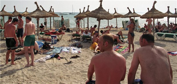 Hautkrebs: Die frühen Sonnenbrände der Baby-Boomer treiben die Statistik Menschen in Badekleidung am Strand