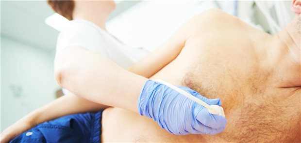 Ärztin macht eine Transthorakale Echokardiographie bei einem Mann.