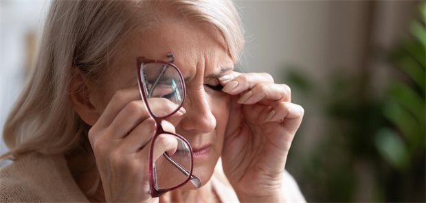 Eine ältere Frau reibt sich die Augen.