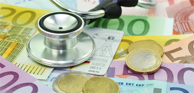 Stethoskop auf einer Krankenversichertenkarte und auf Geldscheinen und Geldmünzen
