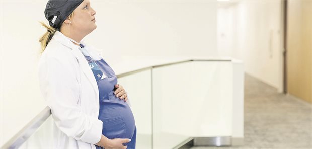 Junge Frau hält ihren Schwangerschaftsbauch