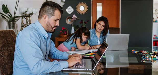 Corona-Pandemie: Frauen und Männer haben auf Stress unterschiedlich reagiert Ein Mann geht seiner Arbeit am Laptop nach, die Frau kümmert sich im Hintergrund um die Tochter.