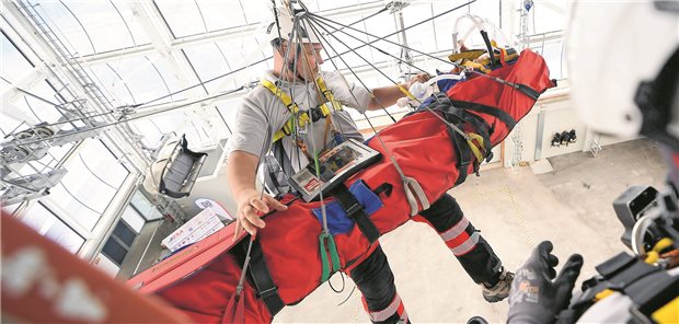 Udo Krodel kommt mit dem Bergesack an der Hubschrauberzelle an. Er und sein Team haben mit der Puppe geübt, sie unter Beatmung in den Bergesack zu legen, zu sichern und schließlich sich zum Hubschrauber hochwinden zu lassen.