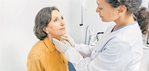 Ärztin untersucht Schilddrüse