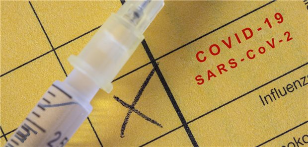 Spritze auf gelbem Impfbuch