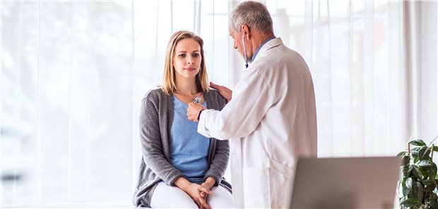 Ein Arzt untersucht eine junge Frau im Rahmen eines Gesundheits-Check-ups.