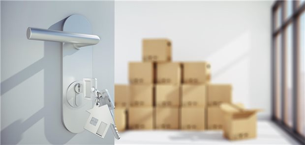 Offene Tür vor heller Wohnung mit Umzugskartons