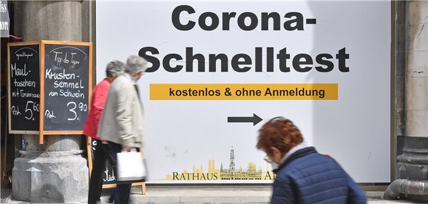 Ärzte bezeichnen Corona-Beschlüsse als enttäuschend Werbetafel für ein Corona-Schnelltest-Zentrum