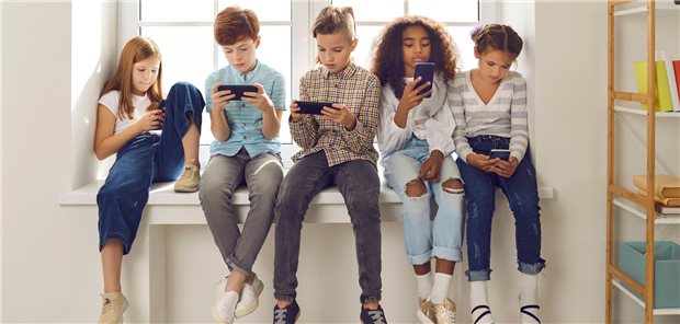 Kinder und Mobilfunk: Welche Gesundheitsgefahren drohen durch 5G? Kinder verschiedener Nationalitäten spielen Online-Spiele oder lesen soziale Netzwerke auf Mobiltelefonen.