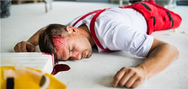 Mann liegt mit blutender Kopfwunde am Boden; die Steinkante vor ihm ist rot eingefärbt (Symbolbild mit Fotomodell).