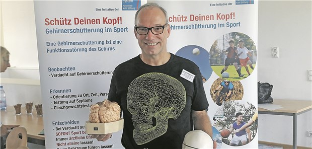 "Nicht jeder Arzt erkennt eine Gehirnerschütterung" Unfallchirurg Dr. Axel Gänsslen mit Modellen eines Gehirns und eines Schädels.