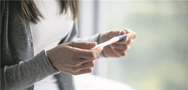Mehrheit der Ärzte Zeitungs-Leserinnen und -Leser für Lehre zu Abruptiones Frau hält einen Schwangerschaftstest in den Händen