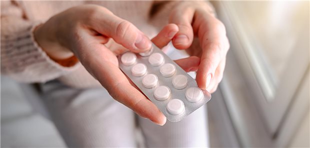 Eine Frau hält eine Blisterpackung mit Tabletten in den Händen.