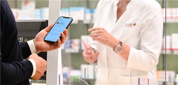 Mann mit E-Rezept in Apotheke.