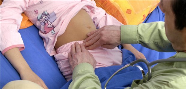 Untersuchung bei Verdacht auf Appendizitis: Gibt es den typischen Loslass-Schmerz nach Druck auf den McBurney-Punkt? (Symbolbild mit Fotomodellen)