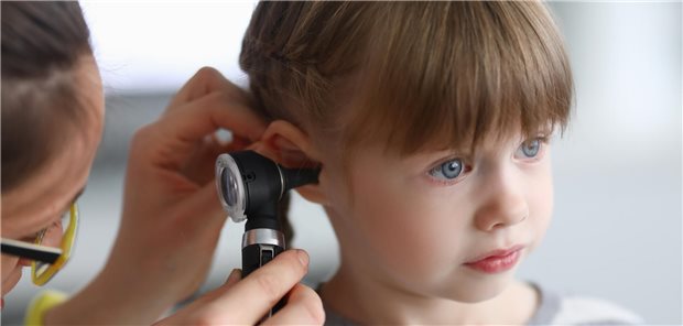 Ärztin untersucht Kind mit einem Otoskop.