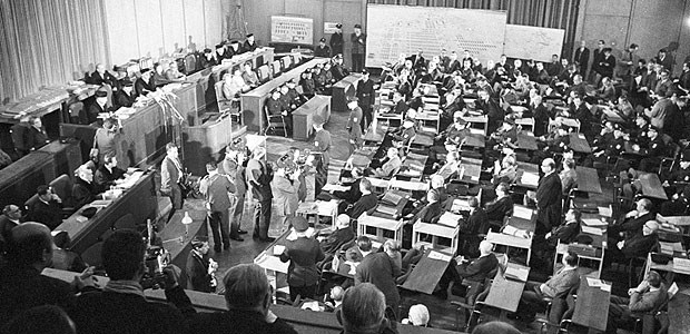 Ärzte auf der Anklagebank Verhandlungstag im Frankfurter Rathaus 1963: Die 22 Angeklagten (r.) wurden von Polizisten begleitet.