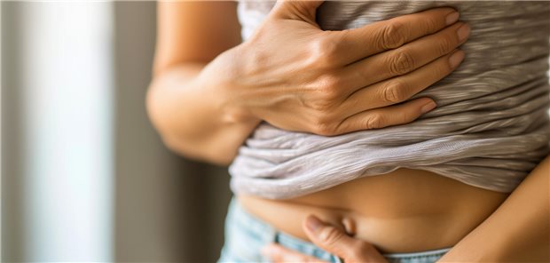 Frau hält sich den Unterleib.