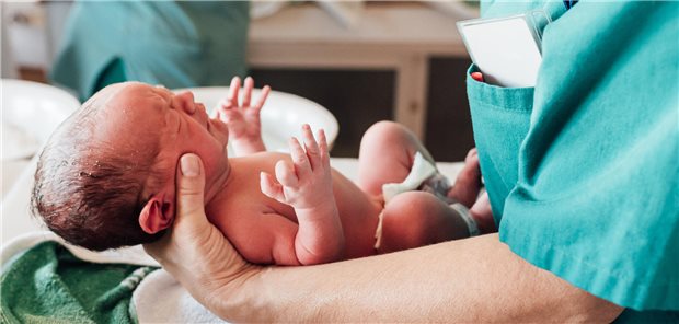 Neugeborenes auf dem Arm einer Ärztin