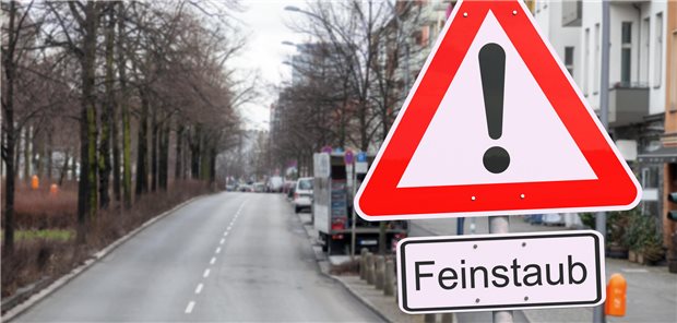 Zu sehen ist eine Straße mit einem Achtung Feinstaub-Schild.