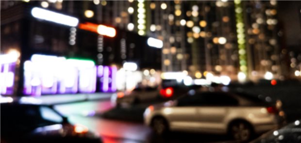 Unscharfe Silhouetten von Gebäuden, Bokeh-Punkte von leuchtenden Straßenlaternen.