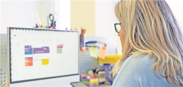 Eine MFA schaut auf den Terminkalender der Praxis.