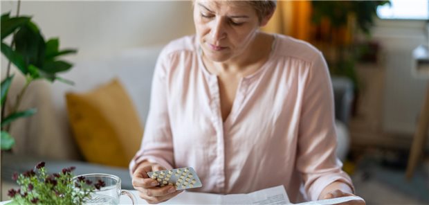 Eine Frau studiert die Packungsbeilage eines Medikaments