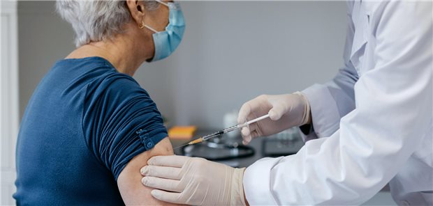 Eine ältere Frau bekommt eine Impfung in den rechten Oberarm.