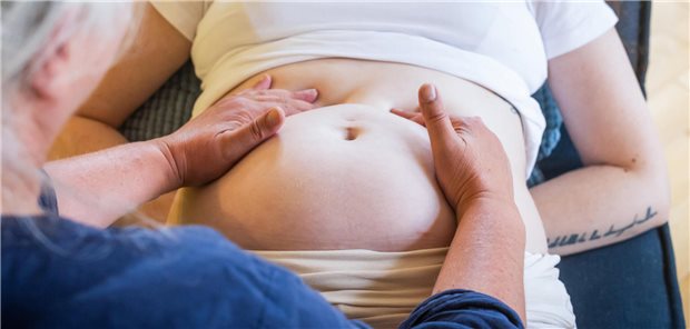 Frau teastet Bauch einer Schwangeren ab.